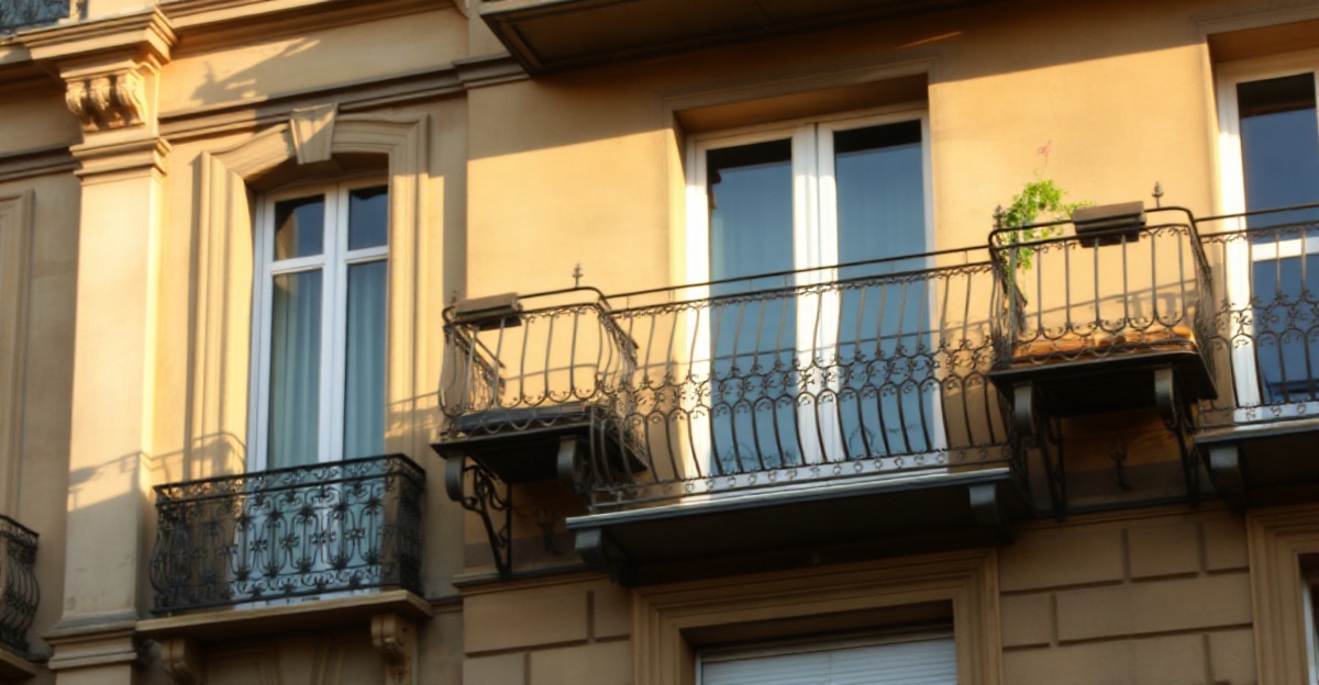Volets en bois fermés sur une façade haussmannienne bordelaise baignée de lumière dorée estivale